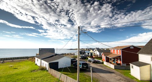 Power poles and transmission lines overlooking a narrow road along the Discovery Trail on Canada's East Coast at a small maritime community.