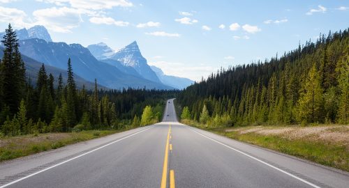 Scenic road in the Canadian Rockies during a vibrant sunny summer day. Taken in Icefields Parkway, Banff National Park, Alberta, Canada.